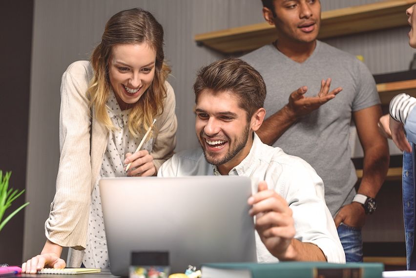 Young startup team celebrating their successful growth achieved through affiliate marketing strategies