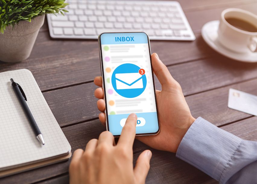 New subscriber checking welcome emails from a newsletter campaign on phone.