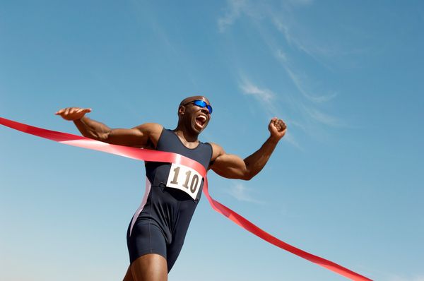 A runner triumphantly crossing the finish line, symbolizing successful email marketing best practices that drive campaigns to victory.