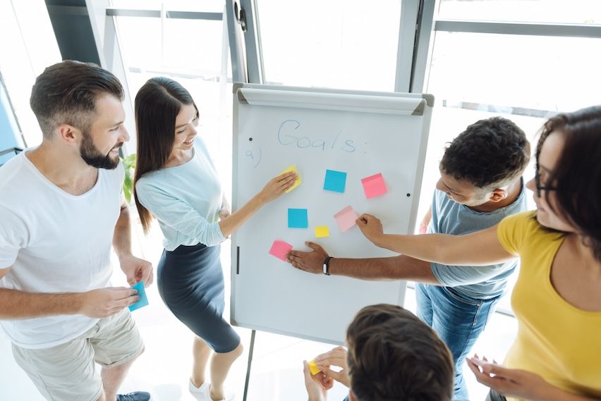 A focused startup team engaged in a strategic planning session, with visible notes or a whiteboard outlining goals and the affiliate marketing roadmap.